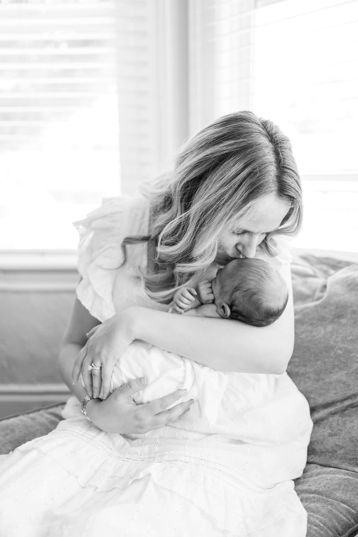 mother kissing her newborn daughter