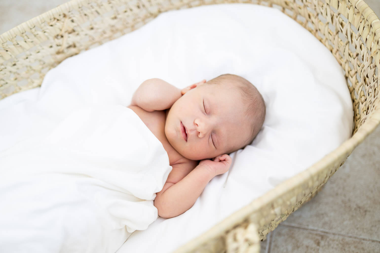 baby sleeping in a moses basket